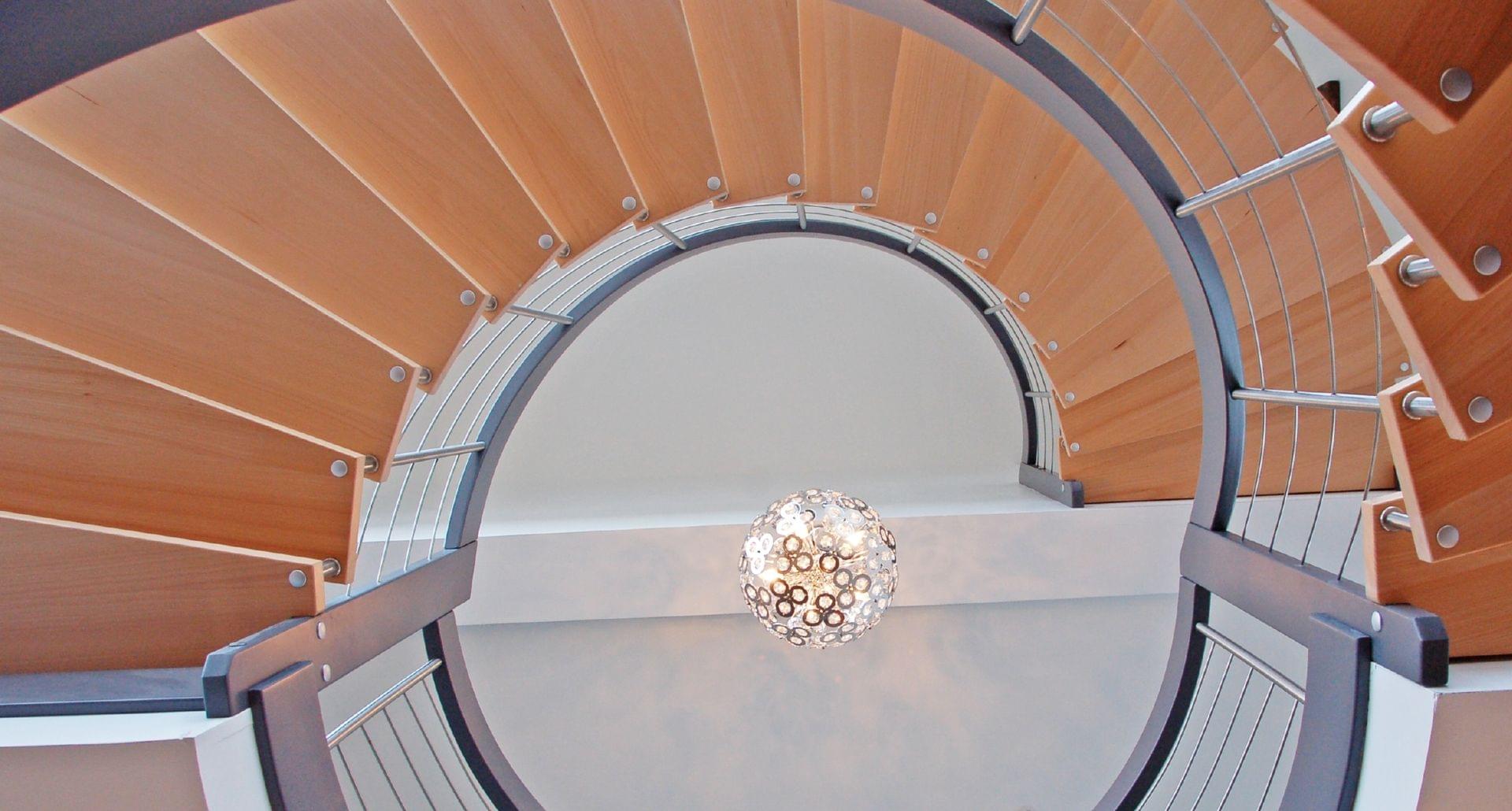 Holztreppe Bogentreppe mit Edelstahl Stäben und mit grau lackiertem Holzhandlauf  von oben
